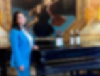 lady-stood-at-the-piano-with-4-wine-bottles-on-top-of-the-piano