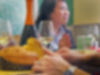 mans hands taking a piece of panettone with woman laughing in back