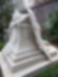statue of a crying angel on a tomb in the cemetery